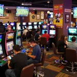 Excited bettors analyzing keobongda odds in a lively modern sports betting venue, displaying vibrant atmosphere.